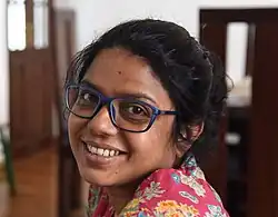Jennifer Latheef smiling and wearing blue glasses