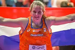 Photo of Jessica Schilder holding up a flag behind her