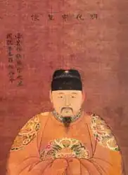 A portrait of a Chinese man wearing a yellow robe and a black cap