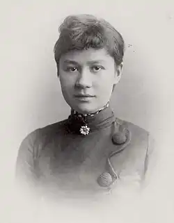 Black and white formal head shot photo of a young woman, with an easy expression and slight smile