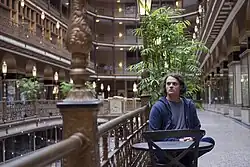 Multidisciplinary artist John Elliott sitting in the Cleveland Arcade building in downtown Cleveland.