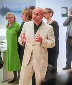 artist Jonathan Parsons, speaking at a gallert with people around