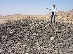 Prof. Joe Greene at a slag heap at Khirbet Feynan, Jordan.