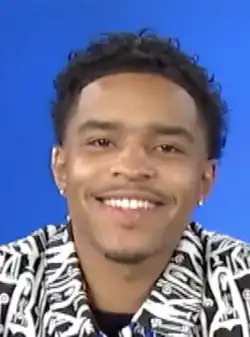 Combs facing a camera and smiling