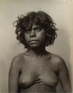 Portrait photograph of a shirtless Aboriginal woman