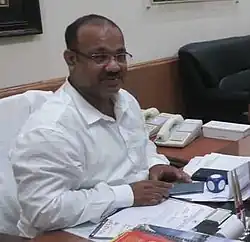 a man wearing glasses at a desk