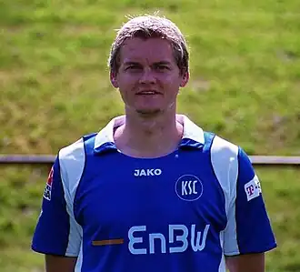 A young soccer player is standing in a field.
