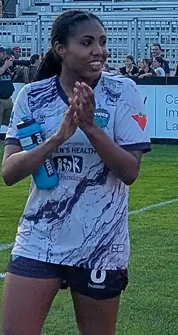 Player in uniform walking and looking to her left