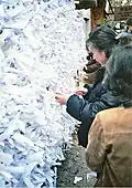 Tying omikuji at Kasuga Shrine