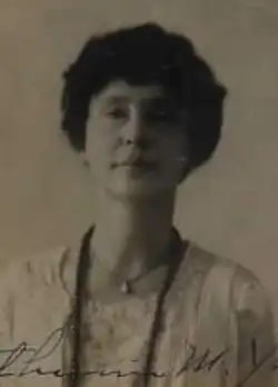 A passport photo of a woman with dark hair and olive skin