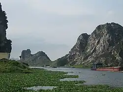 A river with marshy grass and bordering rocky cliffs