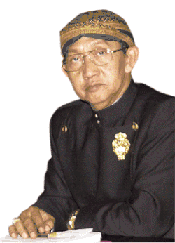 Ki Manteb Soedharsono wearing Javanese traditional attire (beskap and blangkon).