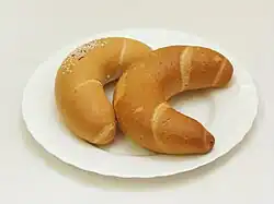 Two crescent-shaped bread rolls on a white plate