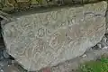 Serpentiform and circular art on kerbstone