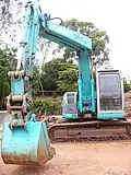 Knuckle boom seen on a tracked excavator, shown at the right extent of travel.