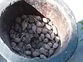 Korarima fruits in a mortar, ready to be crushed .