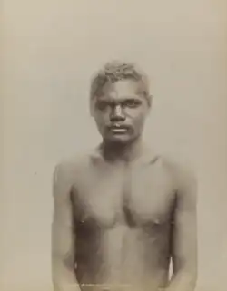 Portrait photograph of a shirtless Aboriginal man