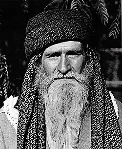 Portrait photo of a man wearing a long white beard and a turban