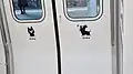 The mascot Kuro originally from the Asobo-i! express line, featured on the side doors of the BEC819 series train.
