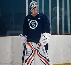 Ice hockey player in a Seattle Kraken jersey wearing goalie equipment
