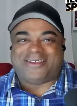 Lamarr Wilson smiling and looking at the camera during a podcast recording.