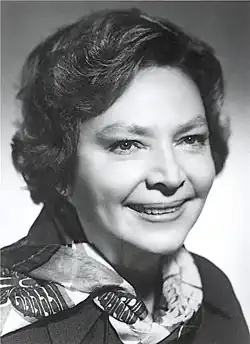 black-and-white close-up image of Libuše Havelková wearing a scarf, looking just left of camera with a grin