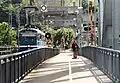 View from the bridge built in 1925 with a tram heading for Gåshaga and a man fishing from the bridge.