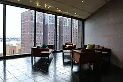 One of the offices on the eastern side of the building, facing outward toward a brick apartment building in the background. The office has furniture such as desks and chairs.