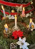 Advent wreath with one rose candle and three blue ones, plus a central white one