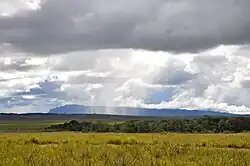 A tepui seen from a distance, with rain in between