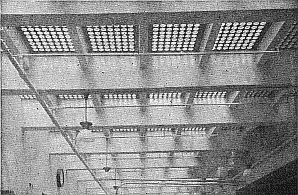 A bright grid of glass with deep cross beams and shallow along-sidewalk beams.