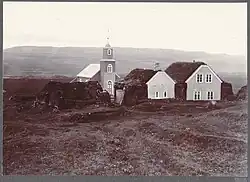 a sepia-toned picture of a farmhouse and small church