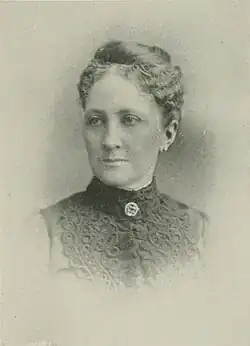 B&W portrait photo of a middle-aged woman with her hair in an up-do.