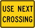 W10-14aP Use next crossing (plaque)