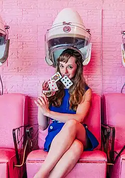 Female Magician on a Pink Background Performing Cardistry