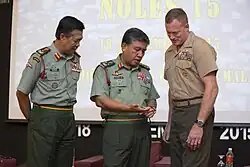 Ahmad Hasbullah Mohd Nawawi, then the Deputy Chief of Army, pictured with a U.S. Marine Corps brigadier general and another Malaysian Army general. Both Malaysian generals are seen wearing the No. 3 Working Dress with the Royal Malay Regiment stable belt. Officers of lieutenant colonel rank and above wear red gorget patches on the collar.