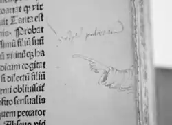 Hand-drawn hand and sleeve extending from the edge of a manuscript to a line of text