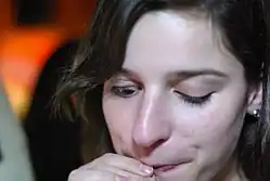Marcus Gunn phenomenon: the woman cannot control her eyelids while drinking. This is a particularly mild case.