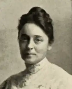 A white woman with dark hair in an updo