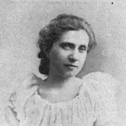 19th-century B&W portrait photo of a woman with her hair in an up-do, wearing a pale, fitted blouse.