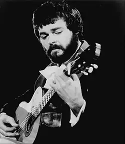 Man with beard playing guitar
