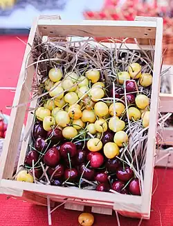 Red and yellow cherries in a wooden box