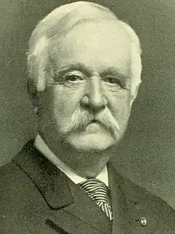 Elderly man with prominent mustache.