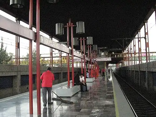 People waiting seated on the station platform.
