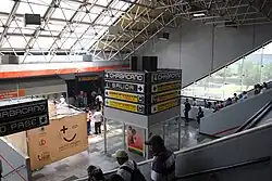 Many people descend the stairs and enter a tunnel.