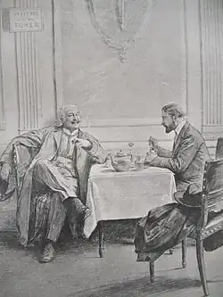 Two men seated at a table in conversation in a restaurant room. One, legs crossed, smokes under a no-smoking sign, while the other enjoys a dish.