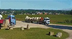 A dump truck carrying rocks from a local quarry, with Batán town in the background
