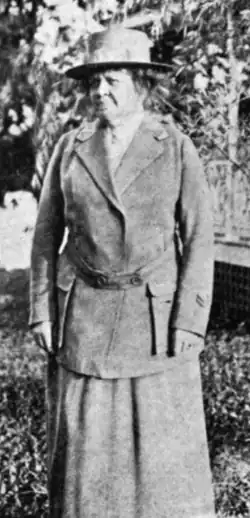 An older white woman, standing outdoors