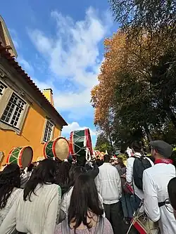 A group of young people with drums, seen from behind
