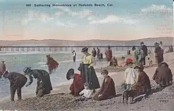 Tourists dressed in 1910 attire picking up moonstones on beach